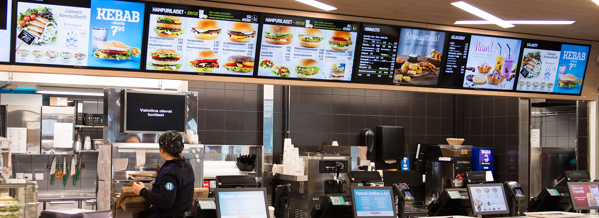 Hesburgerin laaja ja värikäs digitaalinen hintanäyttö kattaa koko tiskin leveyden.